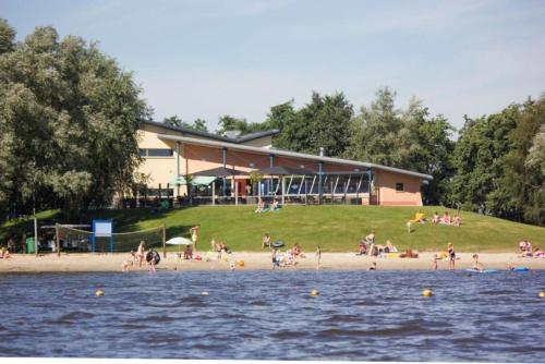 un grupo de personas en una playa cerca del agua en Kajuit423 6pers 5sterren vakantiepark Bergumermeer aan het water in Friesland met zwembad, en Suameer