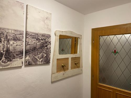 a mirror on a wall next to a wall with pictures at Penzio Ostrava in Ostrava