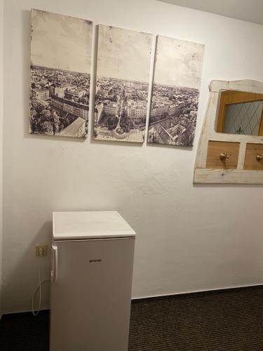 three pictures hanging on a wall with a refrigerator at Penzio Ostrava in Ostrava