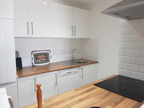 kuchnia z białymi szafkami i zlewem w obiekcie Surf w mieście Estepona