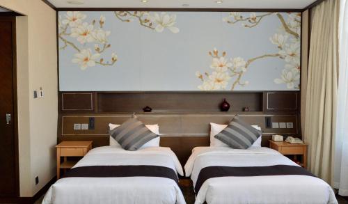 two beds in a hotel room with a large screen at South Pacific Hotel in Hong Kong