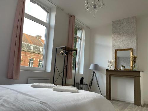 a white bedroom with a bed and a window at NG SuiteHome - Lille I Roubaix I Gare I Métro Alsace - Netflix - Wifi in Roubaix
