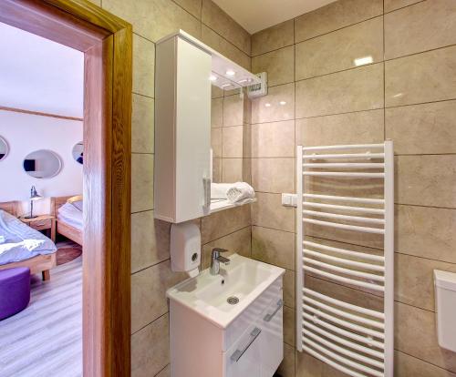 a bathroom with a sink and a mirror at Apartmani Di Casa Dreams in Donji Vakuf