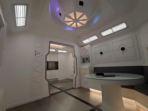 Cette chambre blanche dispose d'une table et d'un plafond. dans l'établissement Space Lodge, vaisseau spatial - jeu type escape game, à Lisieux