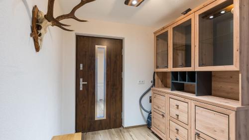 a room with a wooden cabinet and a door at Appartements Bergwelt in Oetz