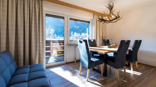 a dining room with a table and chairs and a window at Appartements Bergwelt in Oetz