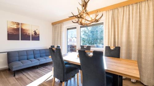 a dining room with a table and a blue couch at Appartements Bergwelt in Oetz