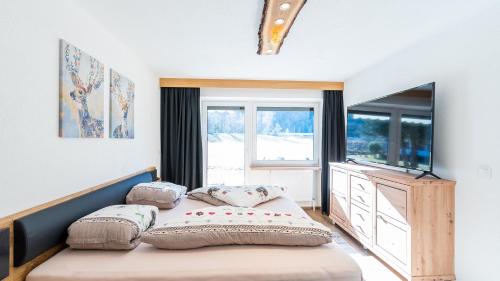 a bedroom with a bed and a large window at Appartements Bergwelt in Oetz