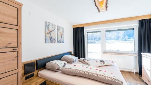 a bedroom with a bed with pillows on it at Appartements Bergwelt in Oetz