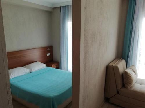 Un dormitorio con una cama azul y una ventana en Dolunaydın Butik Otel, en Side