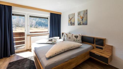 a small bedroom with a bed with a window at Appartements Bergwelt in Oetz