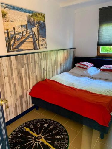 a bedroom with a bed and a painting on the wall at Letnisko Dębki in Dębki