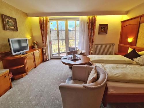 a hotel room with a bed and a television at Parkhotel Bad Faulenbach in Füssen
