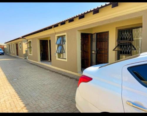 a white car parked in front of a building at AGNES GUEST HOUSE in Germiston