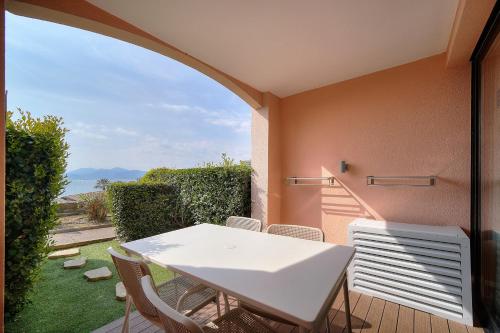 une table blanche et des chaises sur un balcon avec vue dans l'établissement IMMOGROOM - sea view- Pool- Parking- garden, à Cannes