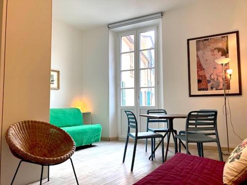 uma sala de estar com um sofá verde e uma mesa e cadeiras em Palazzo Aycardi em Finale Ligure