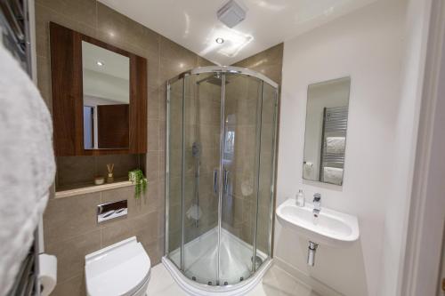 a bathroom with a shower and a toilet and a sink at Oakhill Apartment in Aberdeen