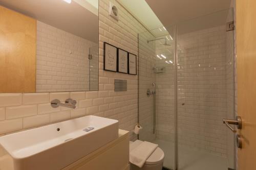 Un baño con lavabo, inodoro y ducha. en ORM - Almada Balcony Apartment, en Oporto