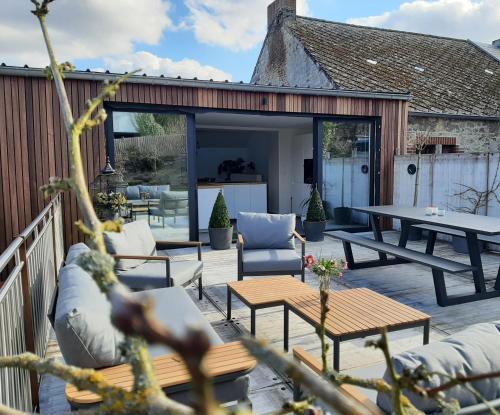 a patio with couches and a table and chairs at Au Cœur des Vallées in Couvin