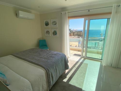 a bedroom with a bed and a view of the ocean at Vila Paz in Carvoeiro