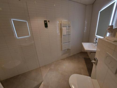 a bathroom with a shower and a toilet and a sink at ibis Styles Almere in Almere