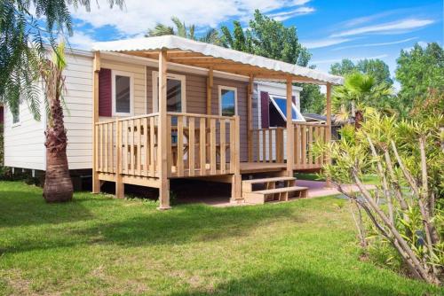 a tiny house with a porch and a gazebo at Camping Country Park Touquin - Site Officiel - Next to Disneyland Paris in Touquin