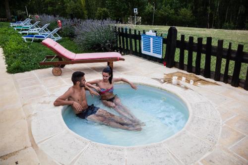a man and a woman sitting in a swimming pool at A. Montesinho Turismo in Bragança