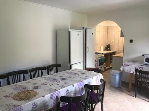 a kitchen with a table and chairs and a refrigerator at Erdei Pihenőház Terecseny in Terecseny
