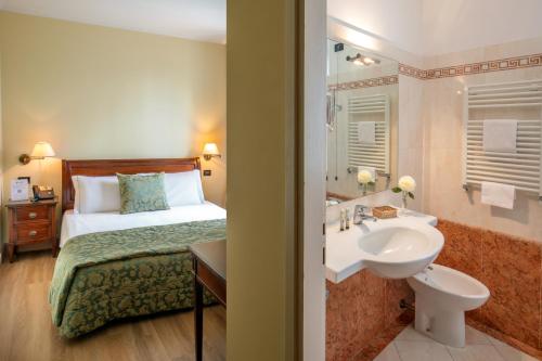 a hotel room with a bed and a sink at Residence Verdeborgo in Grottaferrata