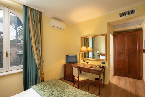 a hotel room with a desk with a television at Residence Verdeborgo in Grottaferrata