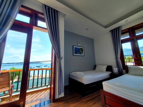 a hotel room with two beds and a balcony at Monkey Homestay & Bar in Tân Hiệp