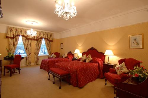 ein Hotelzimmer mit 2 Betten und einem Kronleuchter in der Unterkunft Barberstown Castle in Straffan
