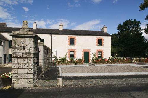 a large white building with flowers in front of it at Castletown Gate House in Celbridge
