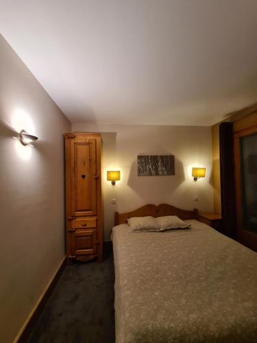 ein Schlafzimmer mit einem Bett, einem Schrank und Lampen in der Unterkunft Garden apartment SPA&Pool in Vallorcine