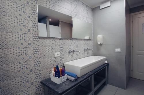 a bathroom with a sink and a bath tub at Grand Hostel Manin in La Spezia