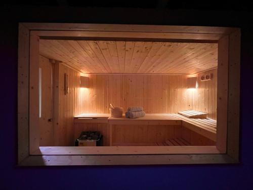 a large wooden sauna with a woodenvisor at Chalet en pleine nature avec Spa in Le Locle