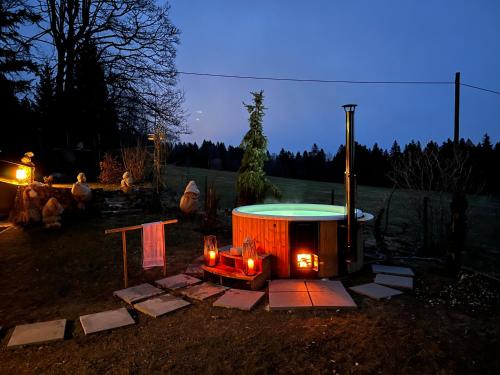 a small hot tub in a yard at night at Chalet en pleine nature avec Spa in Le Locle