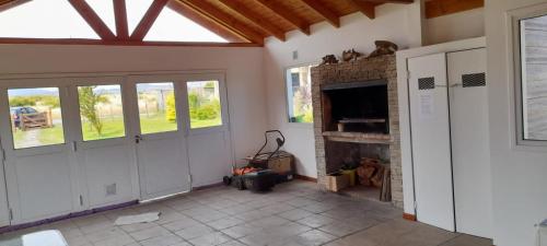 a living room with a brick fireplace and windows at Mi casita en la loma in Trevelin