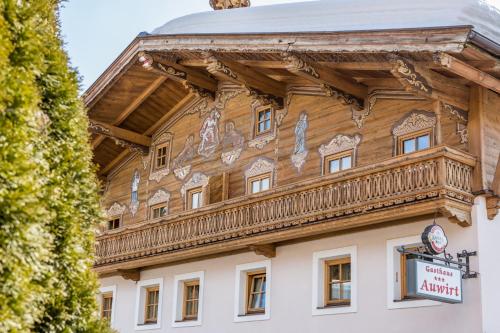 a wooden building with a balcony on top of it at Gasthaus Auwirt in Fieberbrunn