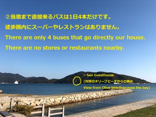 una señal para una casa junto a un cuerpo de agua en Sen Guesthouse, en Shodoshima
