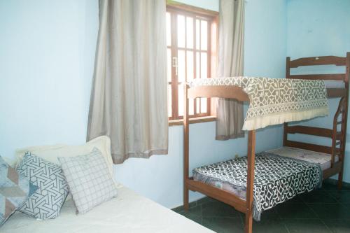 a bedroom with a bunk bed and a window at Sobrado dos Pássaros in Arraial do Cabo