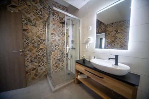 un baño con lavabo y ducha en Manoir Apartments City Center, en Novi Sad