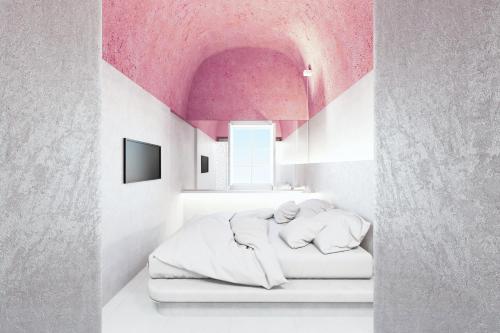 a bedroom with a bed with a pink ceiling at Kykladonisia Traditional Settlement in Fira