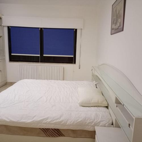 a white bed in a room with a window at Abdoun ground floor apartment in Amman