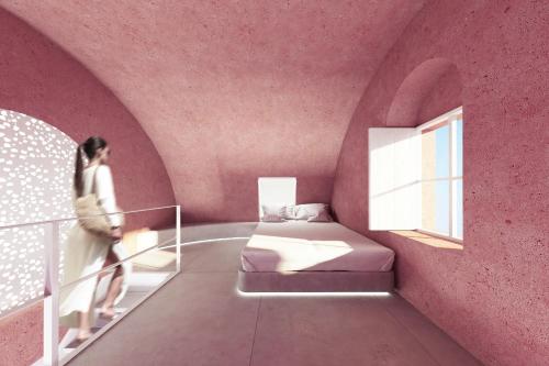 a woman walking in a pink room with a bed at Kykladonisia Traditional Settlement in Fira