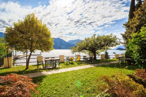a park with tables and chairs next to a lake at Miralago Casa in Menaggio