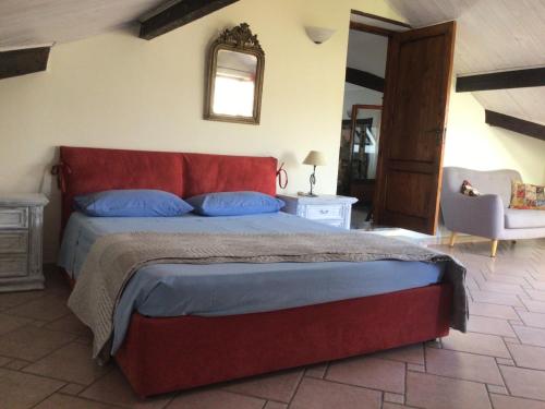 een slaapkamer met een bed, een stoel en een spiegel bij mansarda mare bella vista CITRA zero zero ottanta trentuno LT O738 in Imperia