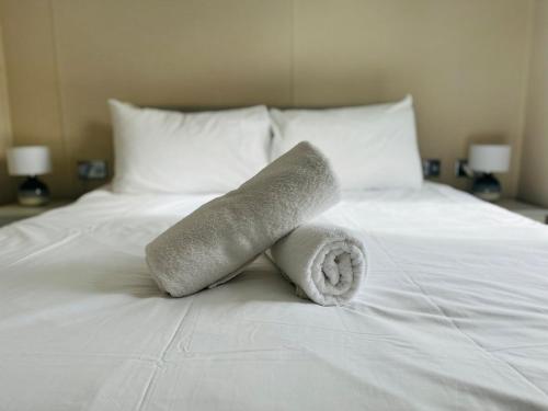 une pile de serviettes assises sur un lit dans l'établissement Fairview Lodge with Hot Tub, à Barmby on the Moor