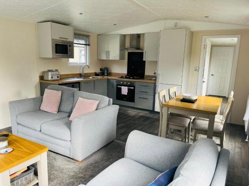un salon avec deux canapés et une table et une cuisine dans l'établissement Fairview Lodge with Hot Tub, à Barmby on the Moor