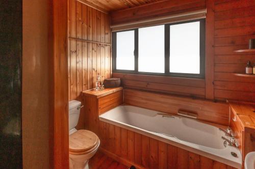 Un baño con bañera y WC. en Stylish and With Stunning Sea Views, en Cape St. Francis